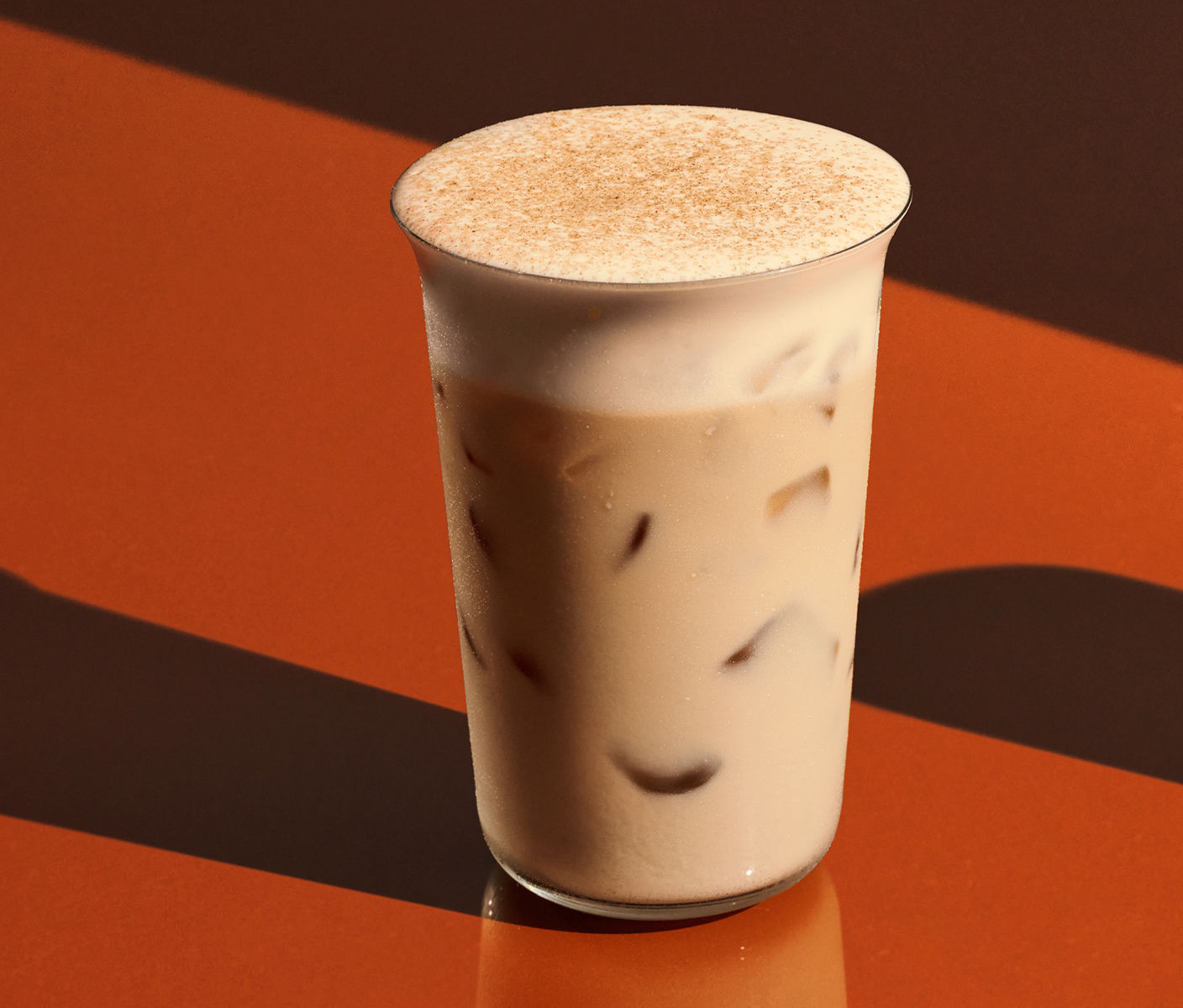 An iced chai with pumpkin cream cold foam and spices.